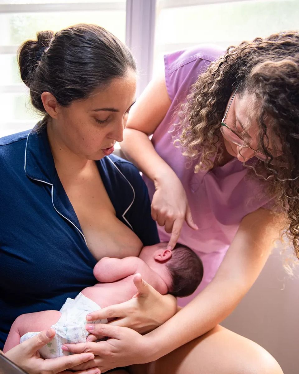 Especialista en lactancia orientando a una madre sobre el agarre y la posición de su bebé