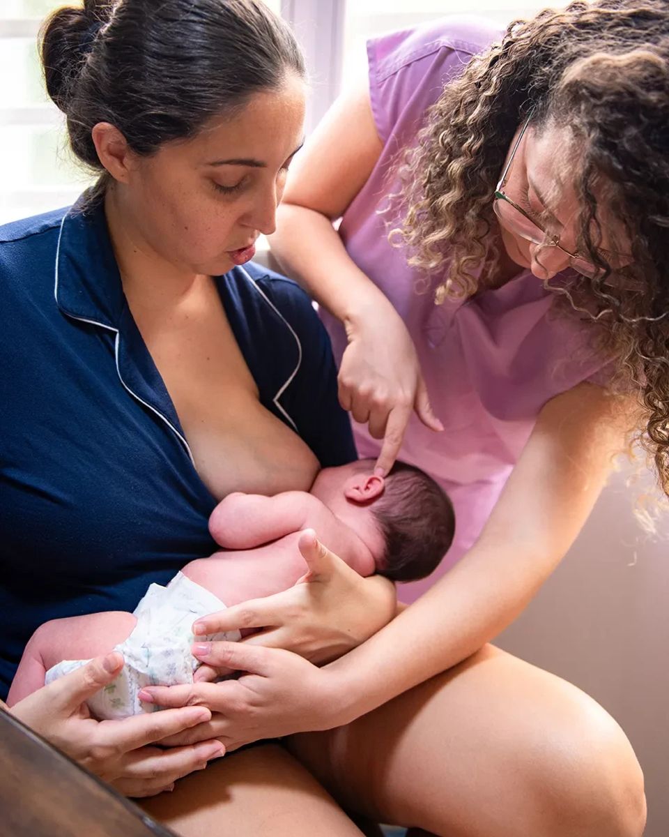 Especialista en lactancia orientando a una madre sobre el agarre y la posición de su bebé