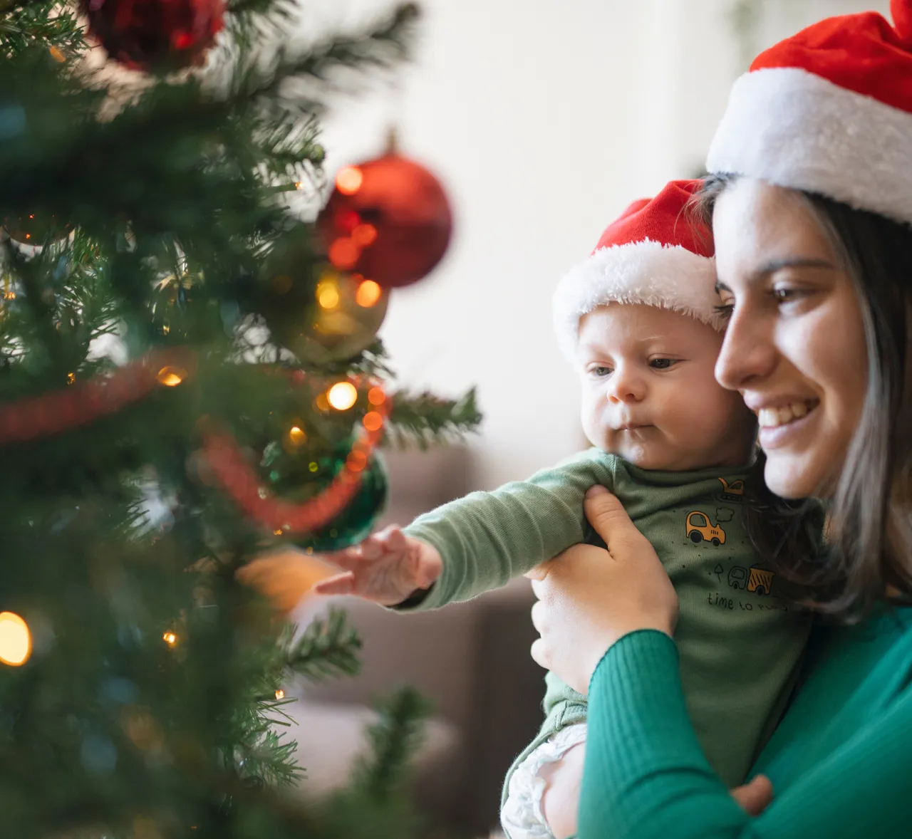 Bebé mirando un árbol de Navidad con luces
