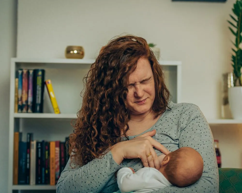 Madre amamantando a su bebé recién nacido, con enfoque en la conexión y el apoyo durante la lactancia, destacando la superación de retos como pezones planos o invertidos