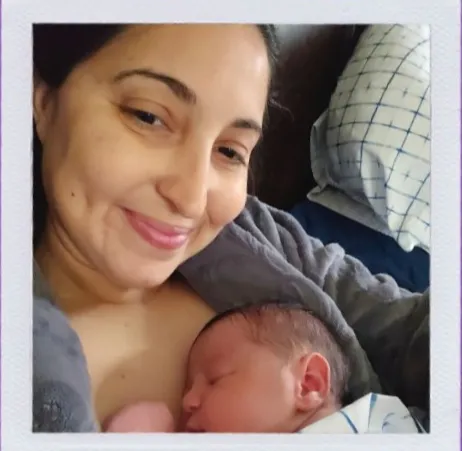 Una madre recién parida sonriente con su bebé recién nacido dormido sobre su pecho piel con piel