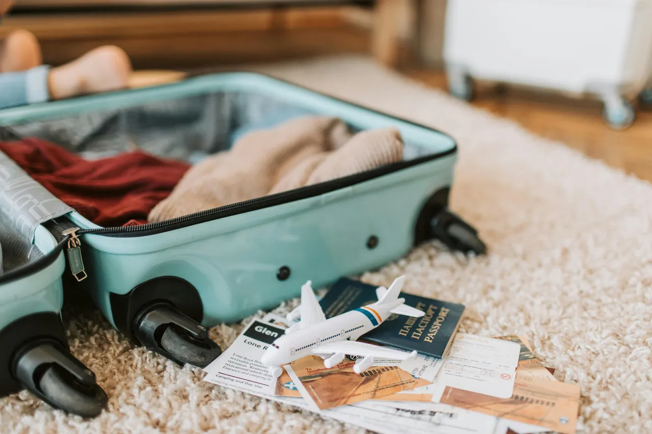 Maleta y pasaporte con juguete de avión Photo by Vlada Karpovich: https://www.pexels.com/photo/black-and-green-luggage-bag-on-brown-carpet-7368191/