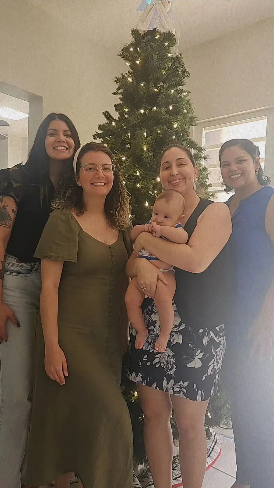 El equipo de Blooming Families Clinic reunido frente a un árbol de Navidad en la última reunión del año 2024, celebrando los logros del año y compartiendo el espíritu festivo.