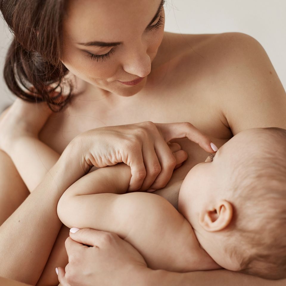 Madre amamantando y abrazando a su bebé recién nacido