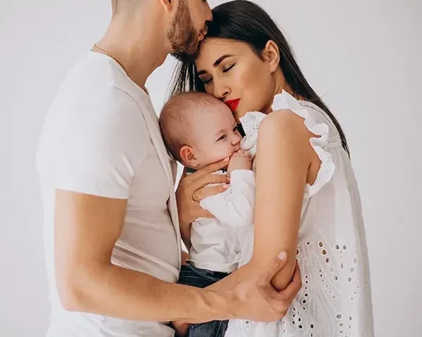 Madre y padre abrazando a su bebé