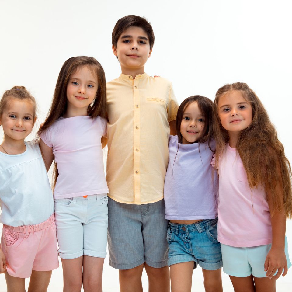 Grupo de niños y niñas sonriendo, de pie uno al lado del otro