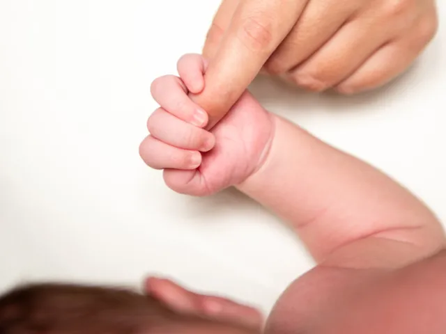 Mano de un bebé sosteniendo el dedo de un adulto